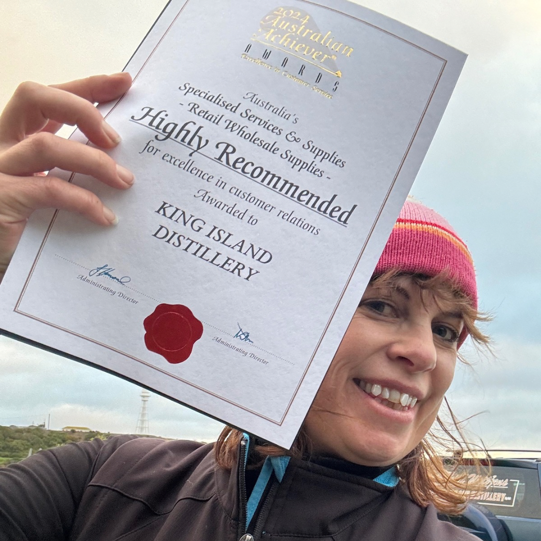 Heidi Weitjens smiling holding Australian Achiever Award Certificate